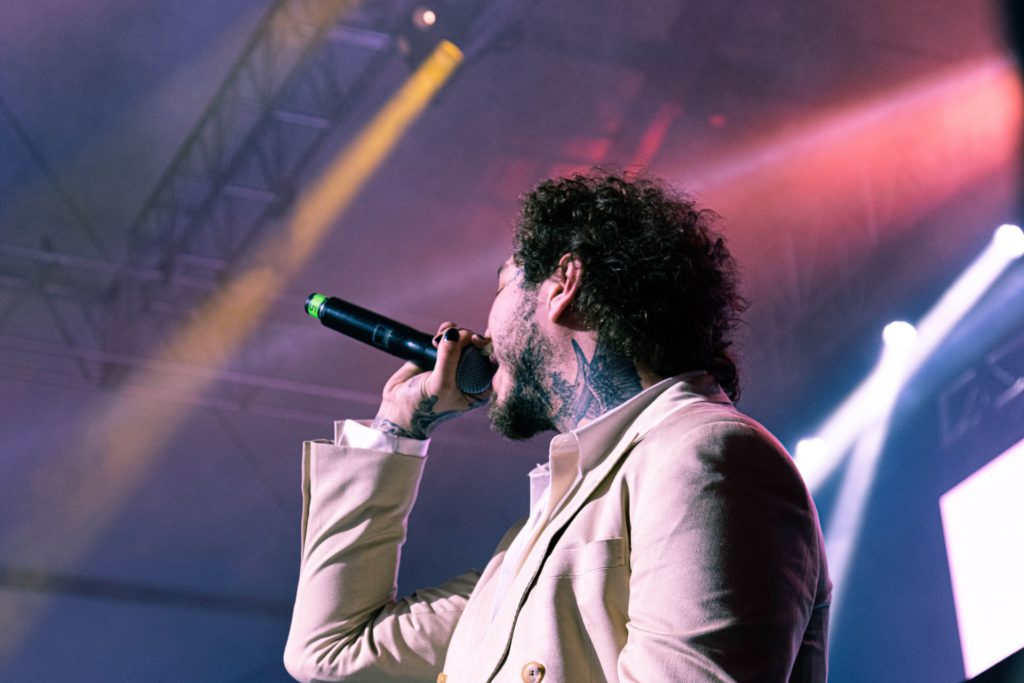 Man in white dress shirt holding microphone